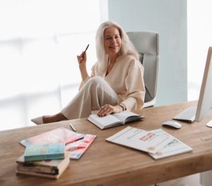 "Focused mature woman at modern workspace demonstrating mental clarity and sustained afternoon productivity